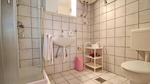 A bathroom with a shower, sink, toilet, and a small shelf with toiletries. - Apartments Neven - Two Bedroom Apartment with Terrace and Partial Sea View (A1) (Drace)