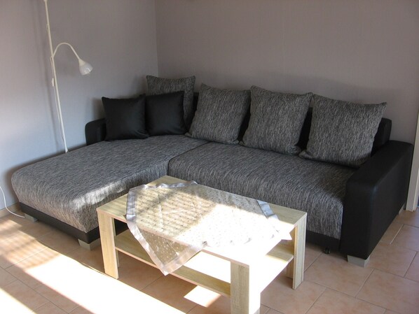 A sectional sofa with a light-colored table in front.