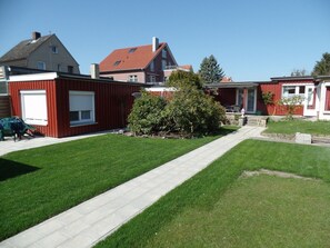 Un quartier résidentiel avec des maisons, une pelouse bien entretenue et un chemin piétonnier dallé.