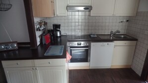 A kitchen with a stove, oven, dishwasher, and a sink. - Apartment '4-Raum Ferienwohnung' with Shared Terrace and Wi-Fi (Cuxhaven)