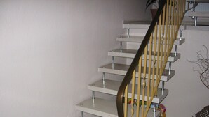 A staircase with a metal handrail and a white wall.