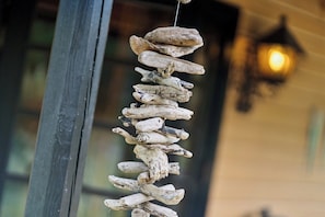 A rustic wooden structure hanging by a window, with a warm light fixture in the background.