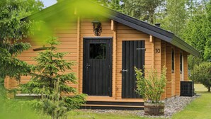 Une cabane en bois avec une porte noire, un petit porche et le chiffre « 10 » peint sur le côté.