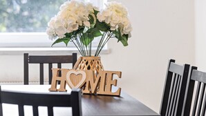 Una mesa de comedor con un jarrón de flores y letras de madera que deletrean 'HOME'.