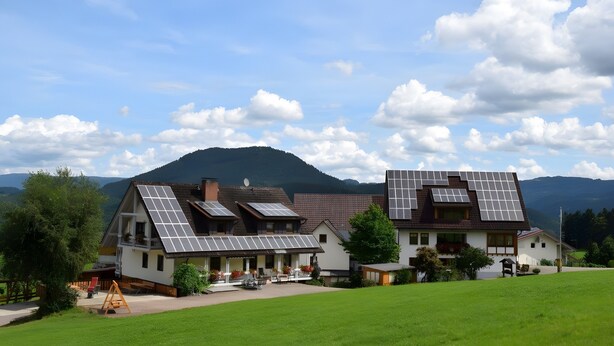 A house with multiple solar panels, a porch, and a lawn. - Löcherhansenhof: Room 'Double Room 2' with Mountain View, Shared Terrace and Wi-Fi (Bad Peterstal-Griesbach)