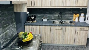 A modern kitchen with light wood cabinets, a granite countertop, a stainless steel sink, and a gas stove. - Sabbia Calda  apt 8 by Comfortbnb (Perissa)