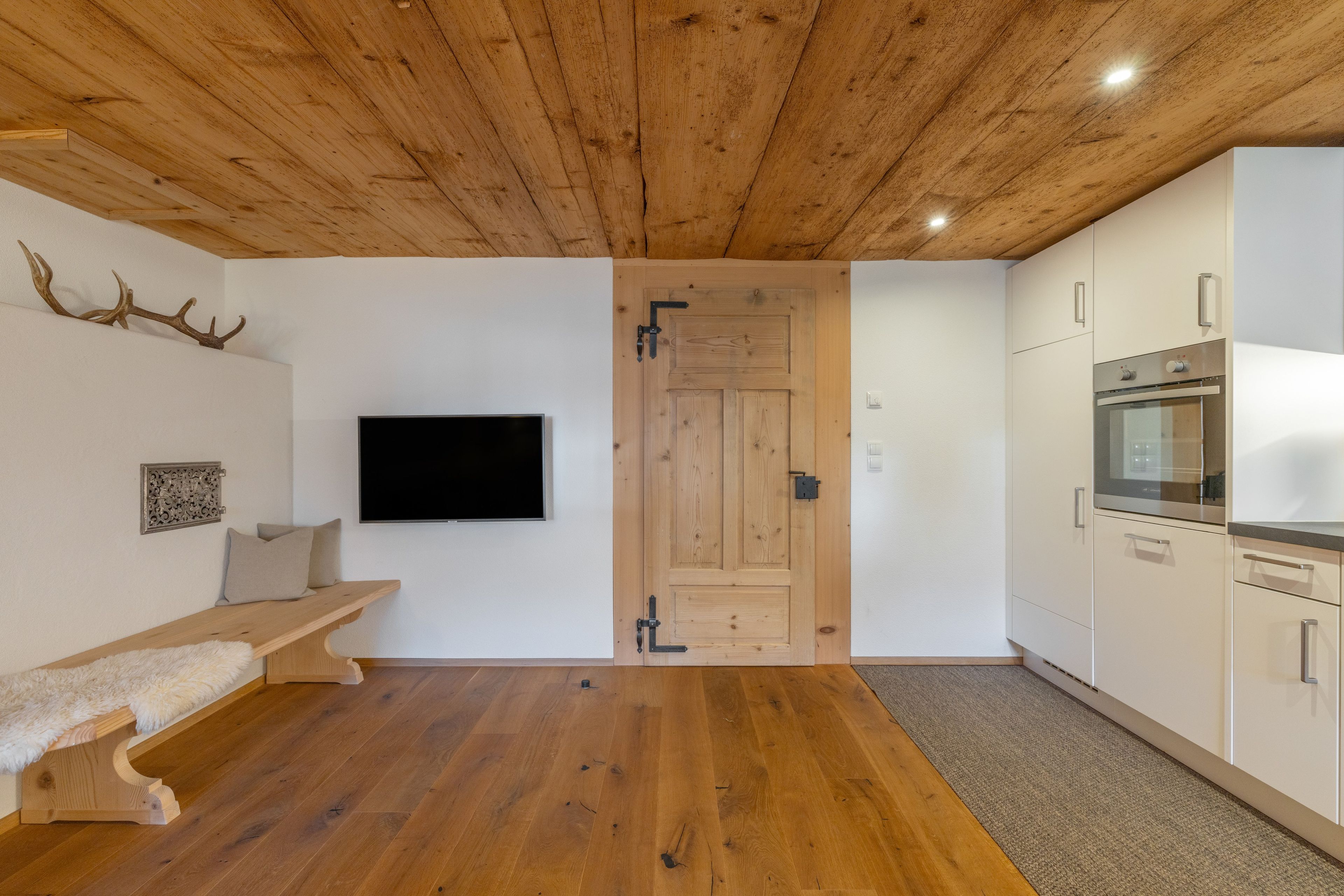 Eine moderne Küche mit eingebautem Backofen und Holzboden.