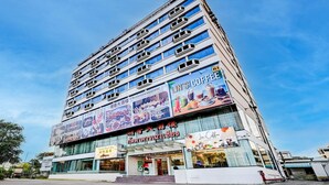 A multi-story building with large signage advertising various businesses, including a coffee shop.