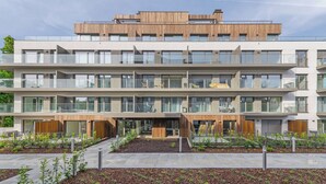 A multi-story residential building with balconies, large windows, and a landscaped courtyard. - Apartamenty Sun & Snow Sand Dunes (Dziwnów)