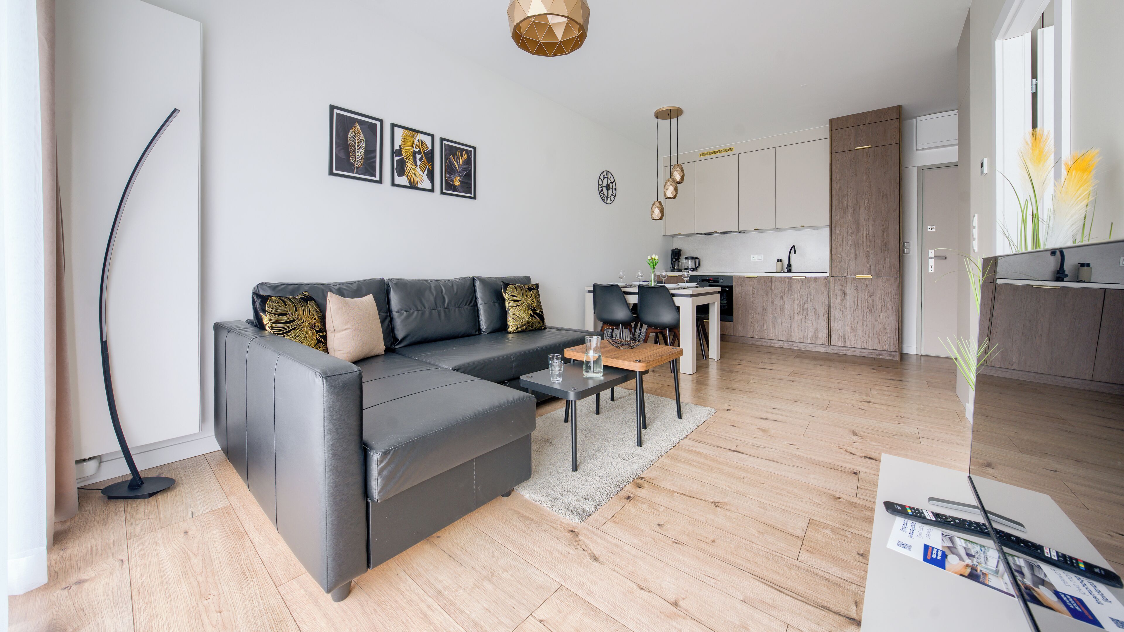 Ein modernes Wohnzimmer mit einem Ecksofa, einem Essbereich und einer Küche.