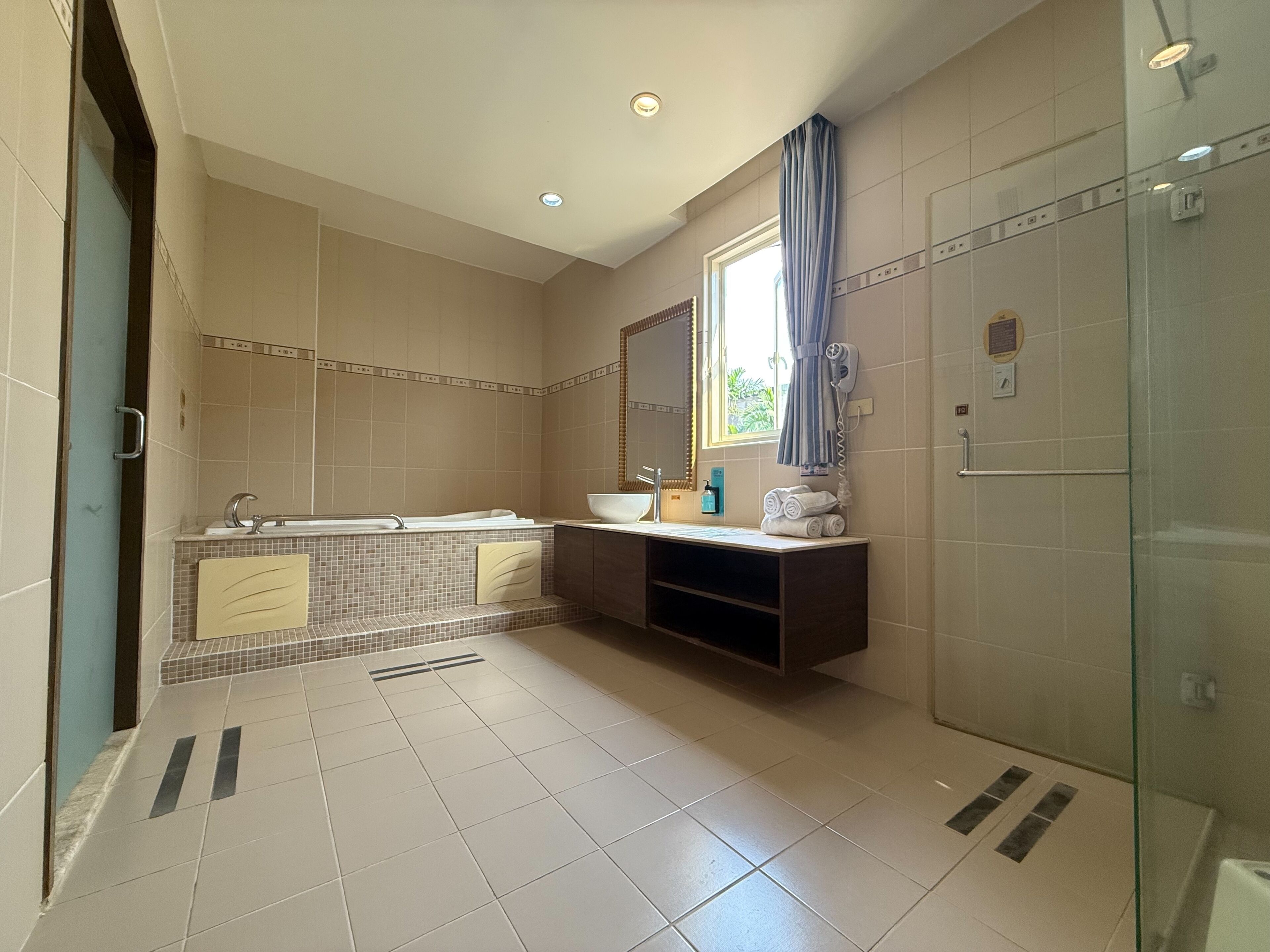 A modern bathroom with a bathtub, vanity, and a glass shower enclosure.