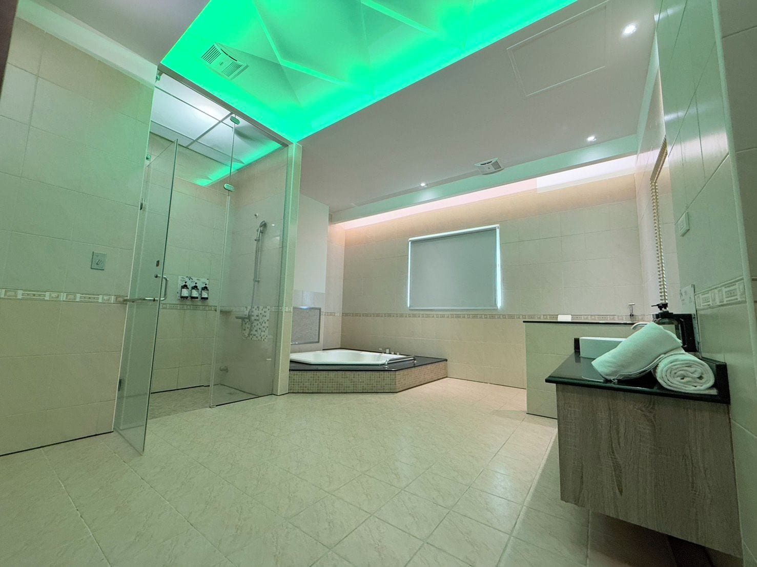 A modern bathroom with a glass shower enclosure, a bathtub, and a vanity with a towel.