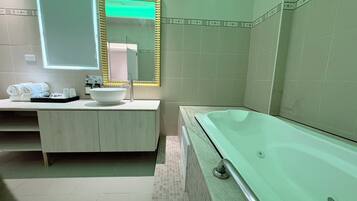 A modern bathroom with a freestanding bathtub, a vanity with a large mirror, and a towel rack.
