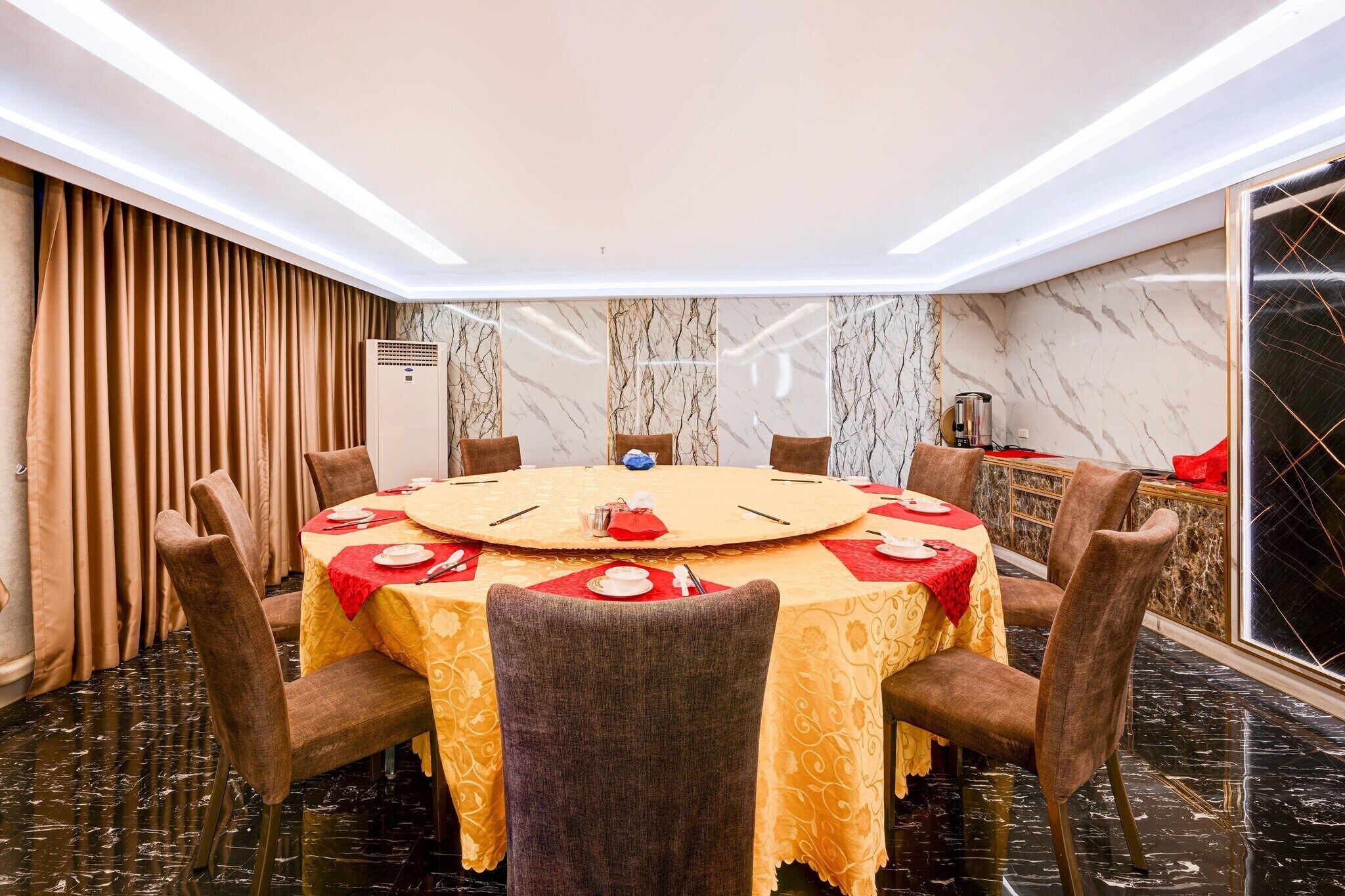 A conference room with a round table, chairs, and a marble wall.