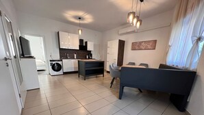 Un appartement moderne comprenant un coin repas, une cuisine et un salon avec un canapé.