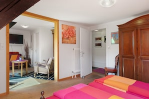 Ein Schlafzimmer mit Bett, Holzschrank und Heizkörper.
