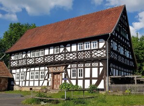 A traditional half-timbered building with a steeply pitched roof, multiple windows, and a visible entrance. - Apartment 'Eva' with Private Terrace, Shared Garden and Wi-Fi (Grebenhain)