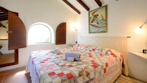 A bedroom with a large bed, a wooden ceiling, a painting, and a window. - Awesome home in Montechiari with WiFi (Montechiari)