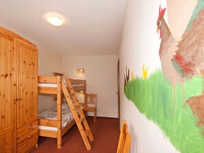 A room with a bunk bed, wooden wardrobe, and a wall painting. - Apartment 'Huhn' with Shared Terrace, Shared Garden and Wi-Fi (Schmallenberg)