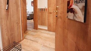 A wooden interior hallway with a door labeled 'Huhn' and a metal rack. - Apartment 'Huhn' with Shared Terrace, Shared Garden and Wi-Fi (Schmallenberg)