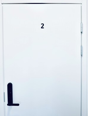 A white door with the number "2" and a black handle. - Katariina Apartments (Kotka)