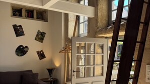 Ein Zimmer mit einer Holzleiter, einer weißen Tür und einem Fenster.