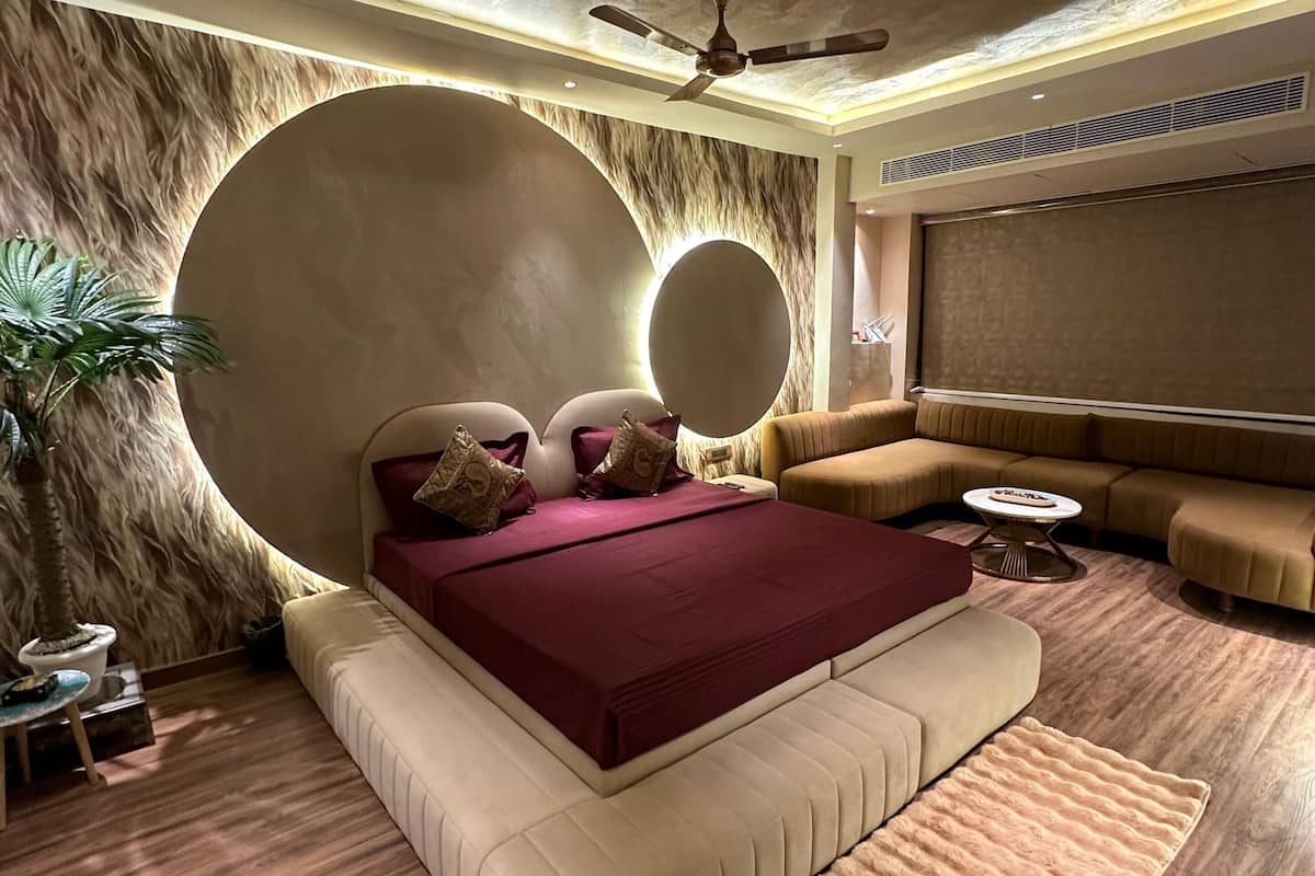 A modern bedroom with a large bed, a ceiling fan, and a large mirror.