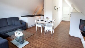A modern apartment with a dining area, a sofa, and a TV. - Apartment 'Hase' with Mountain View, Shared Terrace and Wi-Fi (Schmallenberg)