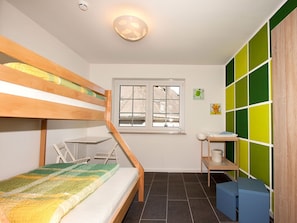 A room with a bunk bed, a desk, a chair, a window, and a wall with a green and white pattern. - Apartment 'Schwein' with Mountain View, Shared Terrace and Wi-Fi (Schmallenberg)