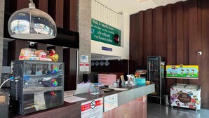 A hotel reception area with a digital display, a no-smoking sign, and a sign indicating daily and monthly room rates.
