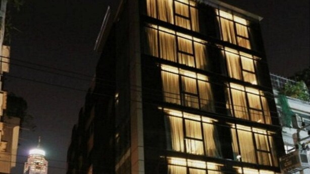A modern building with multiple windows and a sign that reads "The Bangkok."