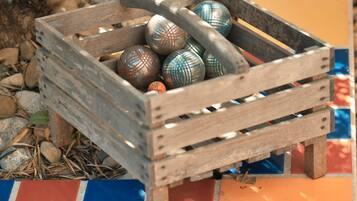 Une caisse en bois remplie d’œufs décoratifs, posée sur un sol carrelé orné d’un motif coloré.