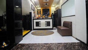 Un soggiorno moderno con un mobile TV nero, un divano marrone, un tappeto decorato e una ventola a soffitto.
