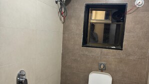 Un bagno piccolo con il water, una doccia e una finestra.