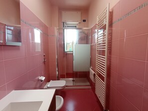 A compact bathroom with a toilet, sink, and shower area. - Giulia's sweet home near Rho Fiera (Pero)