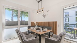 Ein moderner Essbereich mit einem Holztisch, grau gepolsterten Stühlen und einer Bank.