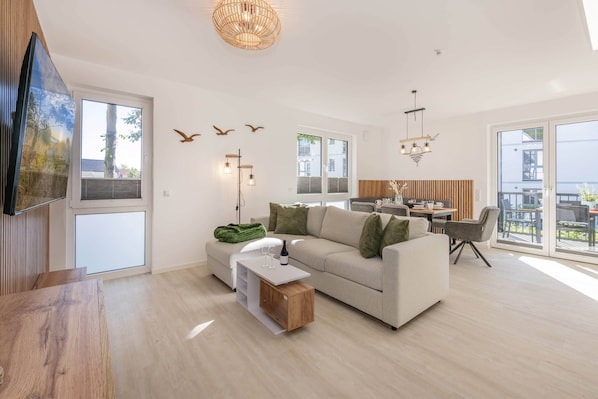 A modern living room with a sofa, coffee table, and dining area.