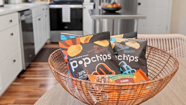 A wicker basket containing Popchips snack bags on a kitchen counter. - The Rover - Market District - 1m to DT Bentonville (Bentonville)