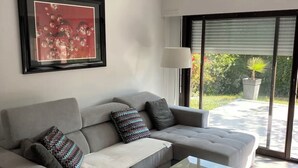 A modern living room with a grey sectional sofa, a glass coffee table, and a framed artwork on the wall. - APPARTEMENT VILLA 7PERSONNES LE CAP D'AGDE Résidence PORT LANO Plage LA ROQUILLE (Agde)