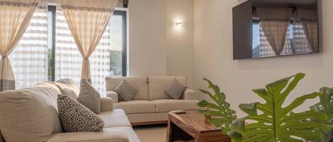 Una sala de estar moderna con un sofá, una mesa de centro y un espejo grande.