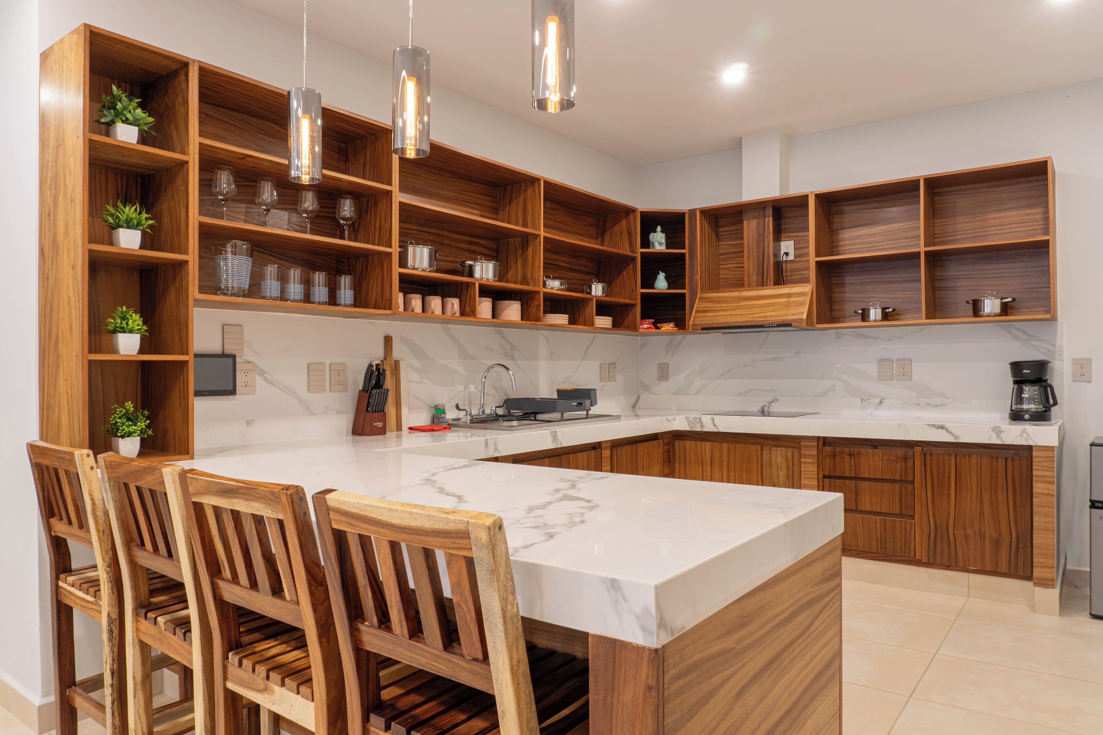 Una cocina moderna con encimera de mármol, armarios de madera y una isla integrada con asientos.