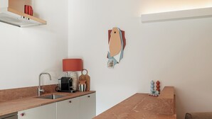 Una cocina moderna con encimera de mármol, electrodomésticos de acero inoxidable y una lámpara roja.