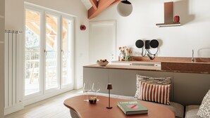 Una cocina moderna con una isla grande, muebles blancos y vistas a la terraza exterior.