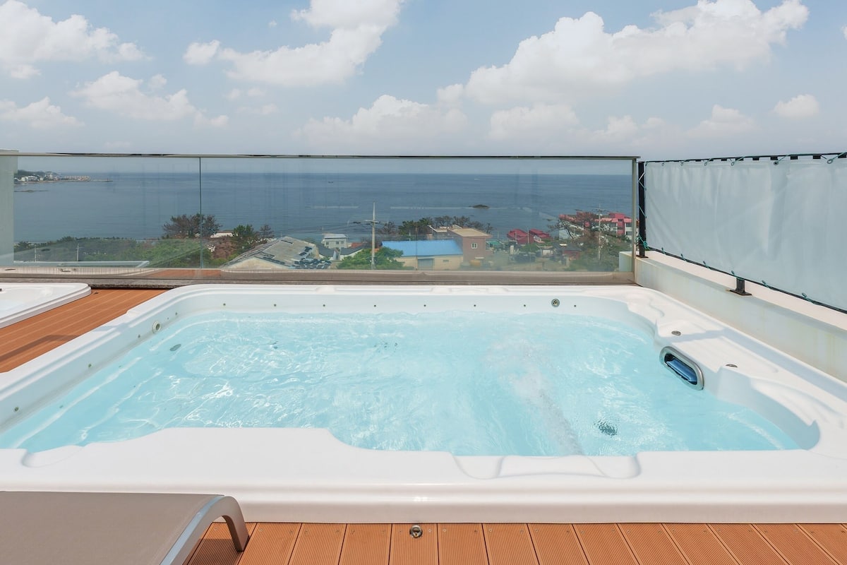 A rooftop terrace with a hot tub and a view of the sea.