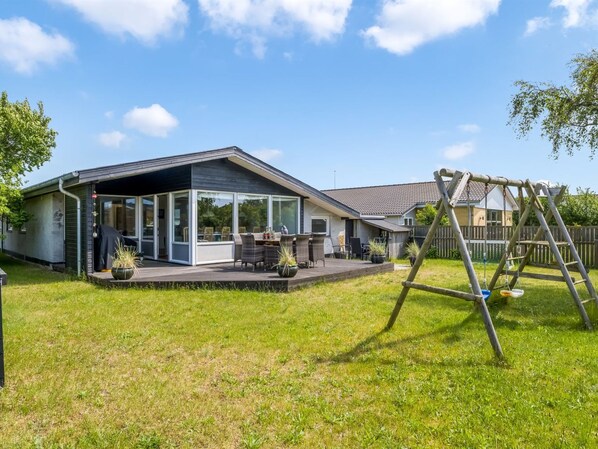A modern house with a covered patio, a swing set, and a fenced yard. - "Yardila" - 900m from the sea by Interhome (Skagen)