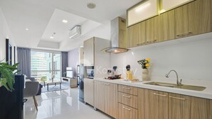 A modern kitchen with wooden cabinets, a stainless steel sink, and a large window providing a view of the city.