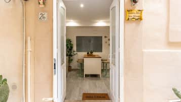 A hotel entrance with a reception desk, a welcome mat, and a sign indicating room number 26.