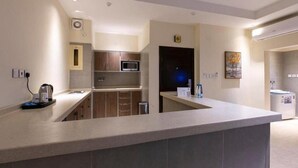 A modern kitchen with a built-in microwave, a coffee machine, and a sink. - Golden new Alsalamah (Jeddah)