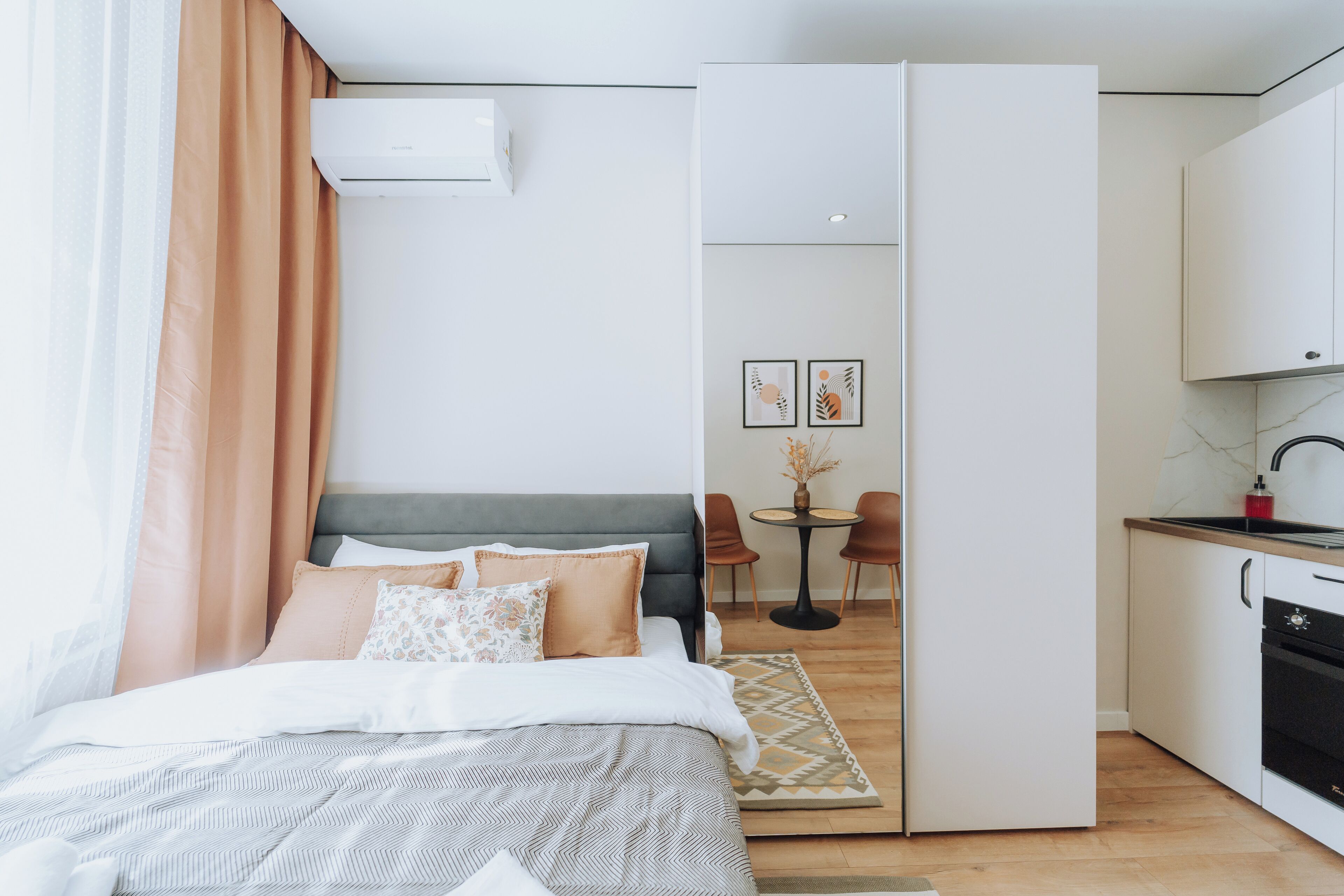 Un dormitorio moderno con cama, escritorio y kitchenette.