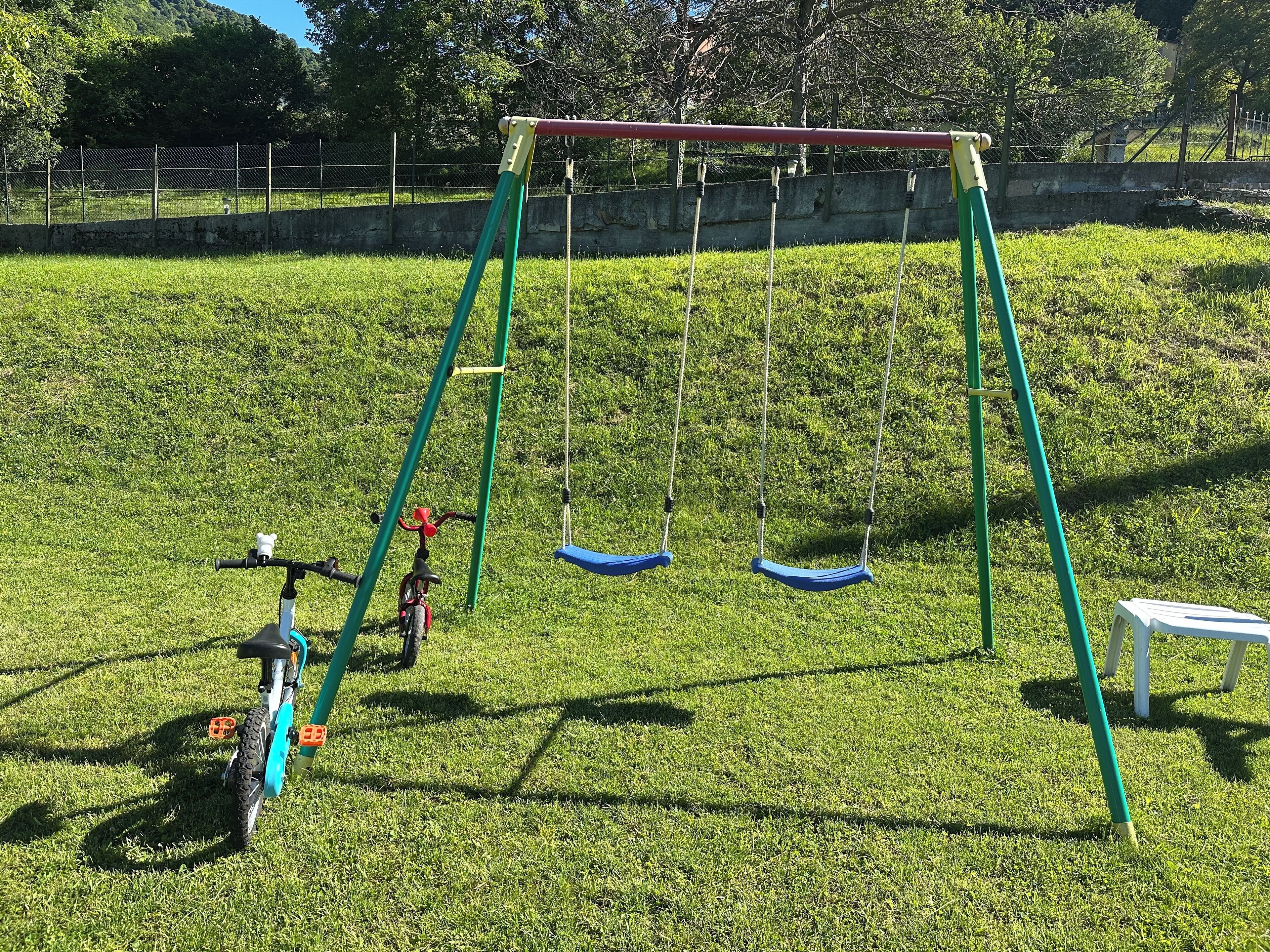 Ein Spielplatz mit Schaukel und Dreirad.